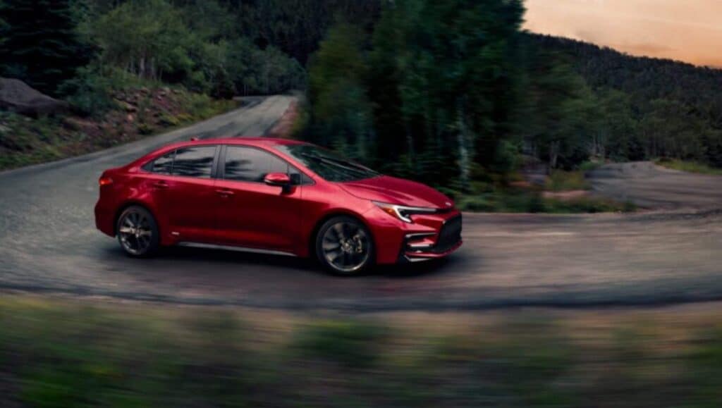 A red Toyota Corolla hybrid in motion