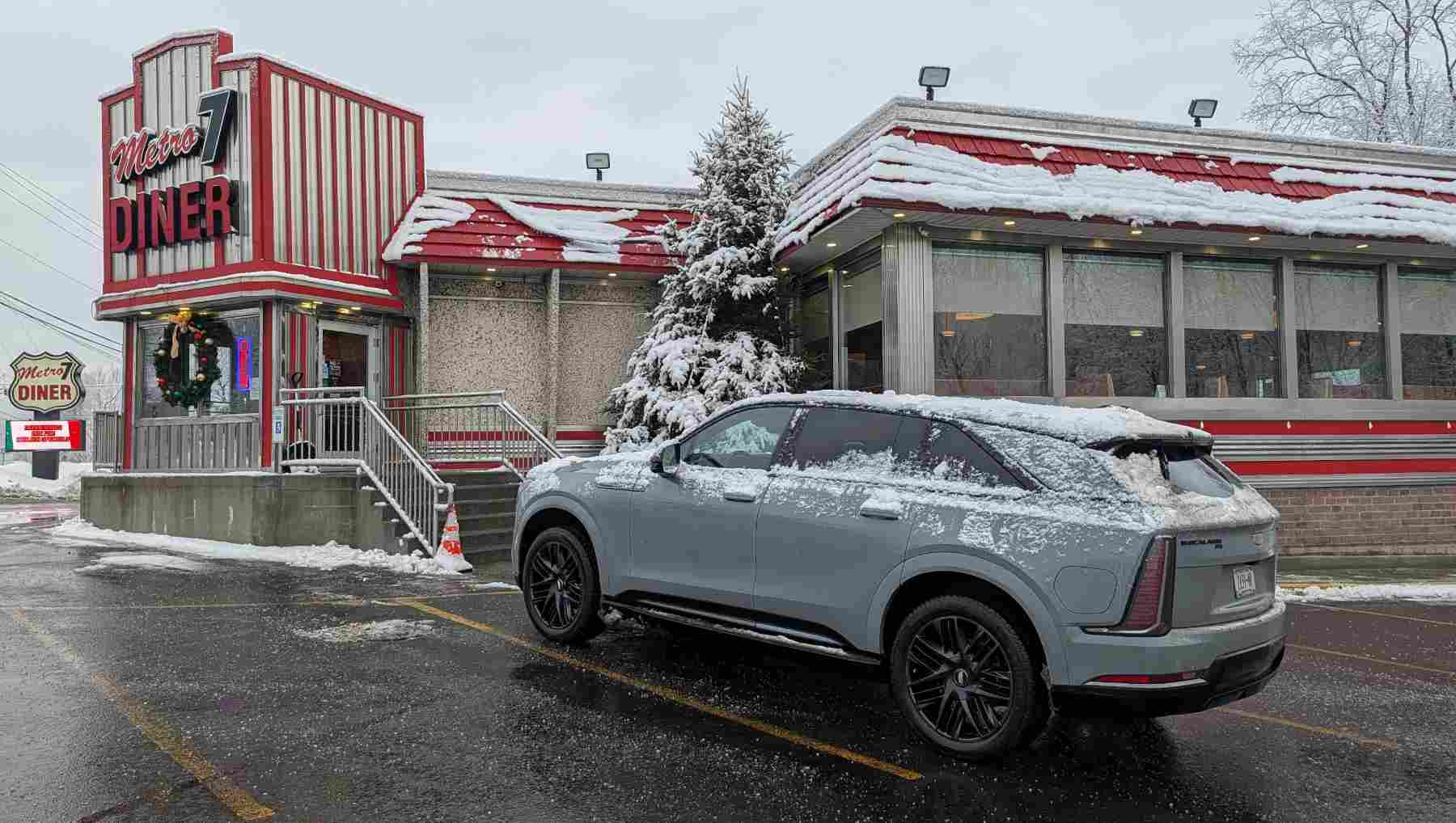 A Cadillac Escalade IQ parked in front of a diner