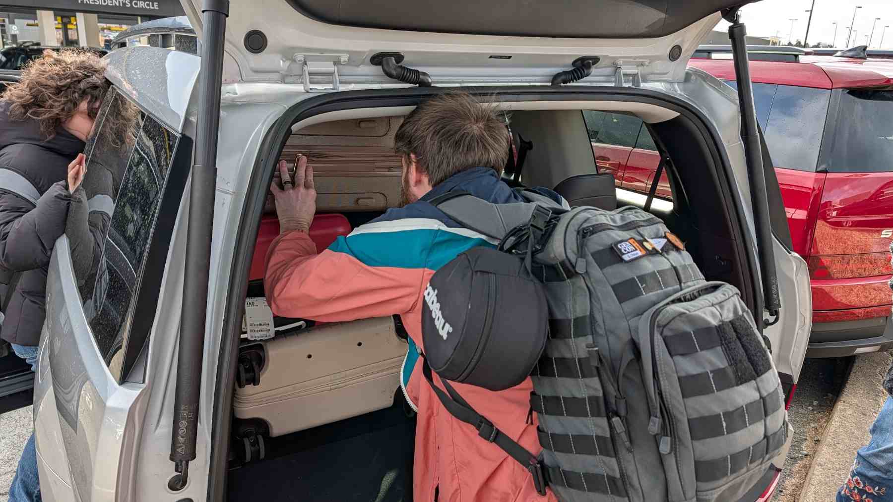 A person loading luggage into a Hyundai Santa Fe