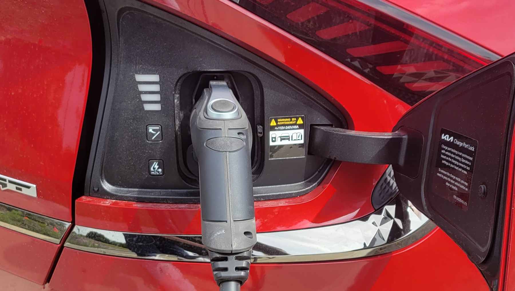 A Kia EV6 charging port with a charger plugged in