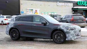 A camouflaged Mercedes-AMG GLC EQ prototype testing in a winter environment