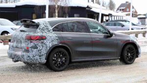 A camouflaged Mercedes-AMG GLC EQ prototype testing in a winter environment