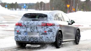 A camouflaged Mercedes-AMG GLC EQ prototype testing in a winter environment