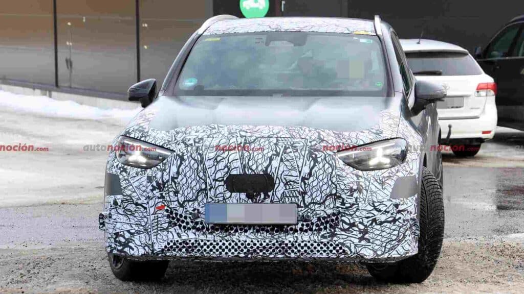 A camouflaged Mercedes-AMG GLC EQ prototype testing in a winter environment