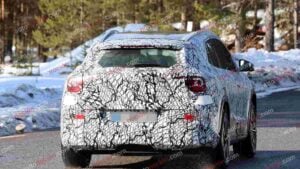 A spy shot of a camouflaged Mercedes-Benz GLA EQ in winter conditiona