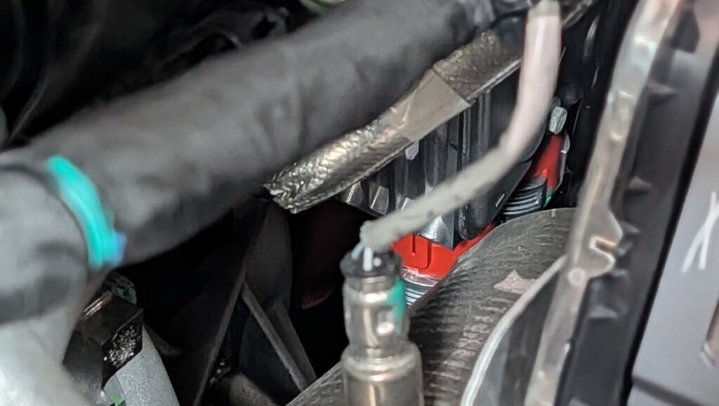 An orange high-voltage connector deep in the Jeep Grand Wagoneer 4xe's engine bay