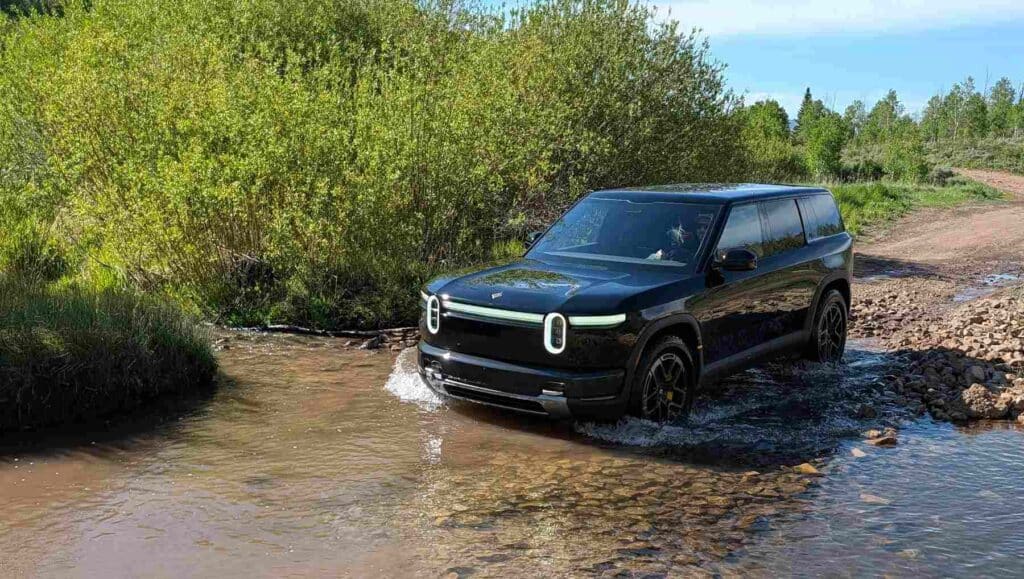 A Rivian R2 crossing a stream