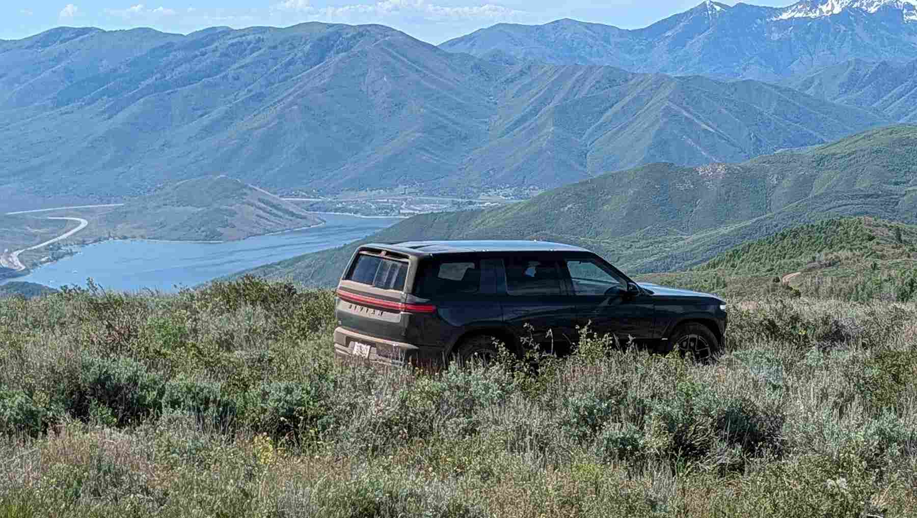 Side view of a Rivian R2 driving on a mountain