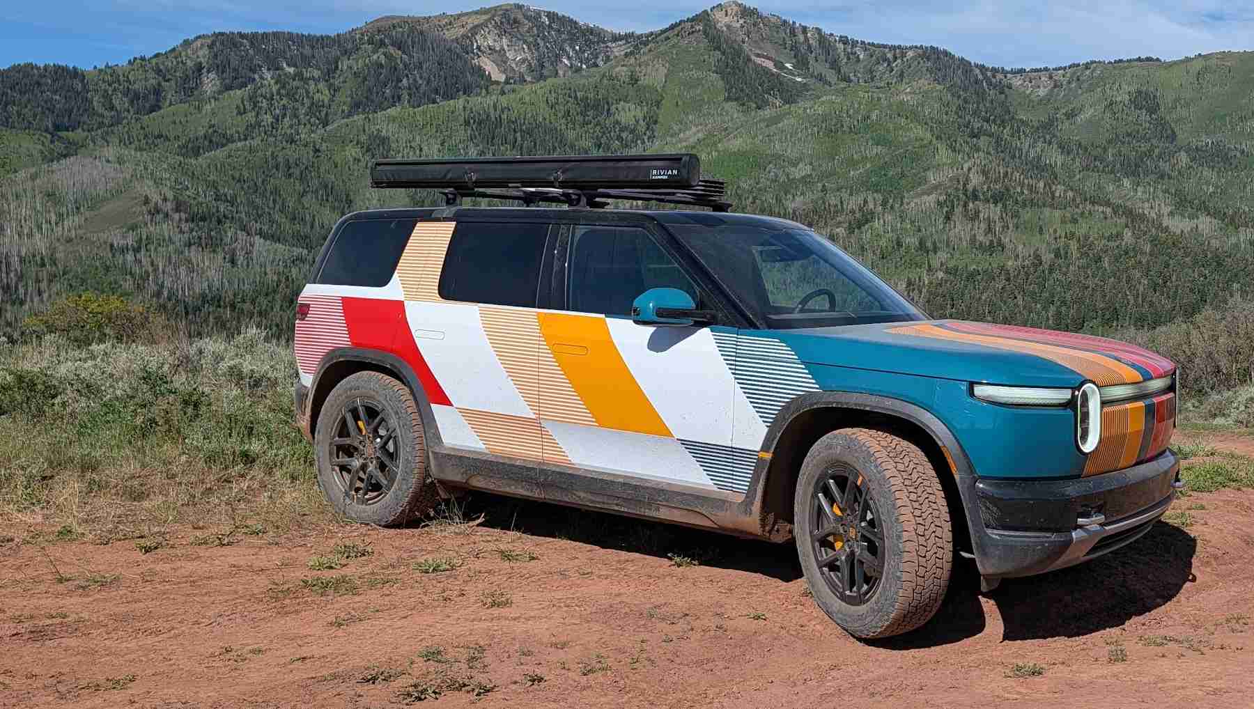 Front 3/4 view of a Rivian R2 on a mountain