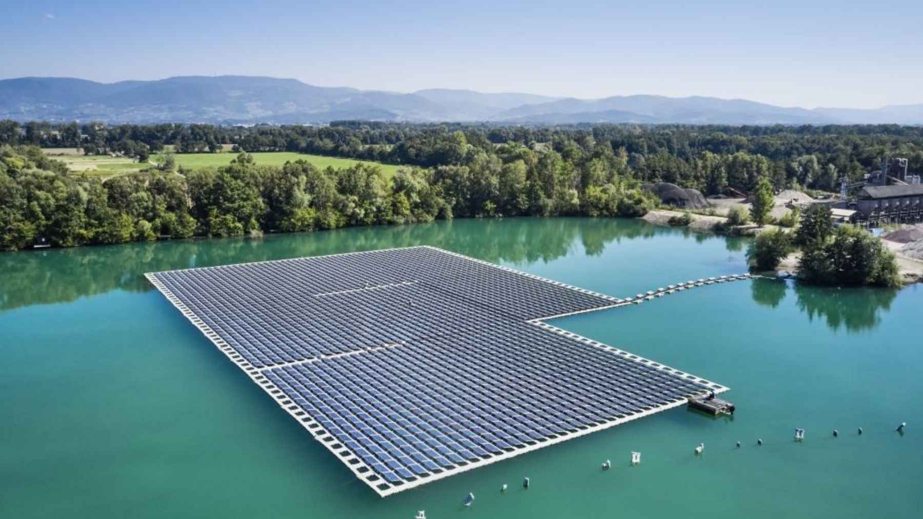 Germany stood 2,600 solar panels dead upright on a Bavarian lake, edge-on to the sun, because a law says you can shade 15% of the water and not an inch more, and the rows lean like sails on underwater keels when the wind loads up
