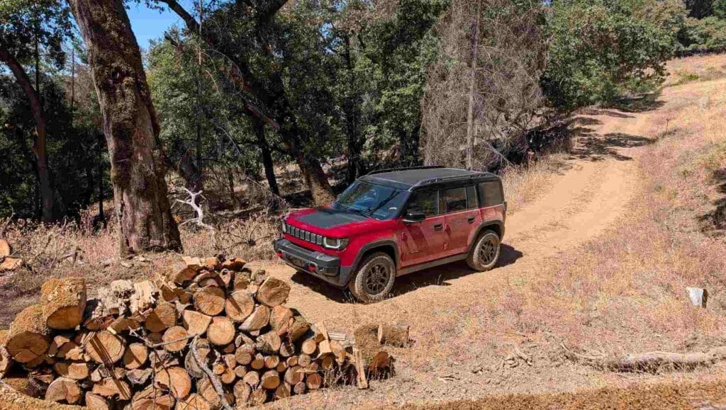 A front 3/4 view of a red Jeep Recon on rough terrain