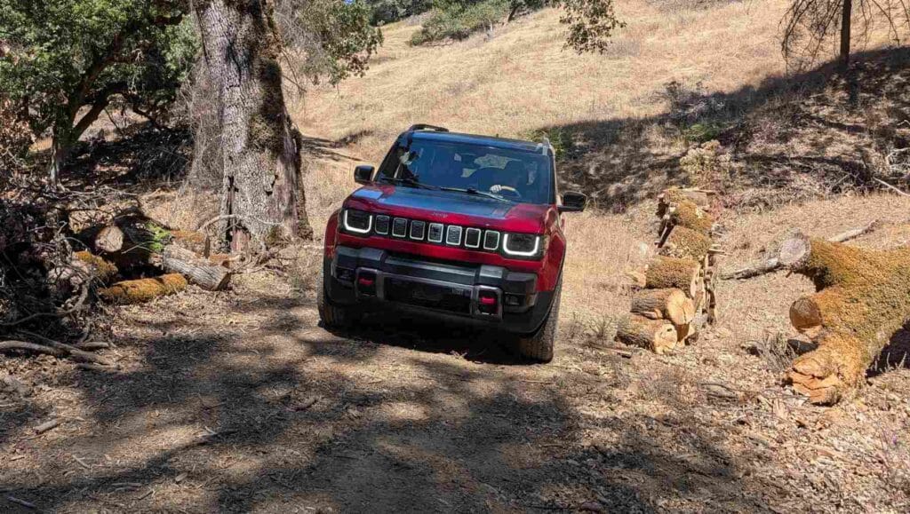 A front view of a red 2026 Jeep Recon on rough terrain
