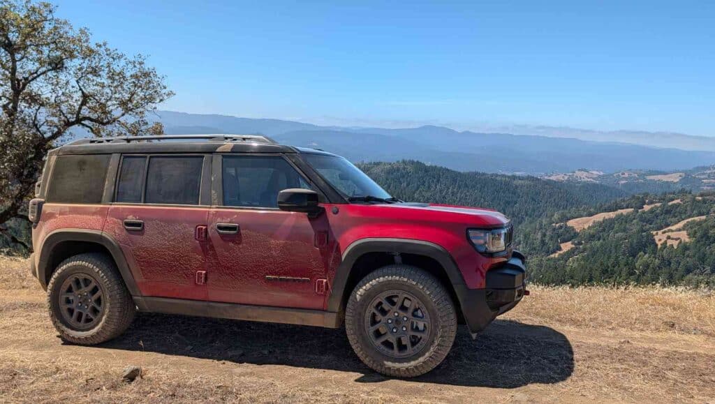 a side view of a red 2026 Jeep Recon with mountains in the background