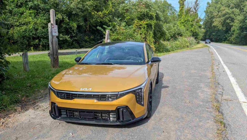 A front view of a gold 2026 Kia K4 in a layby