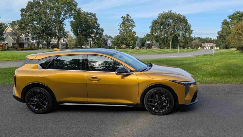 A side view of a gold 2026 Kia K4