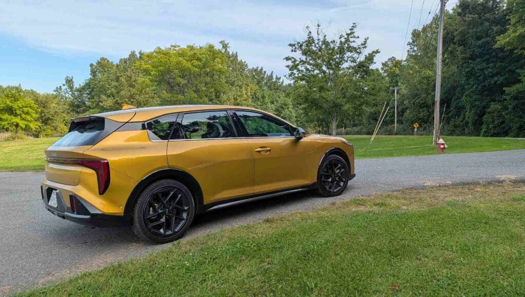 A side view of a of a gold 2026 Kia K4 on a path