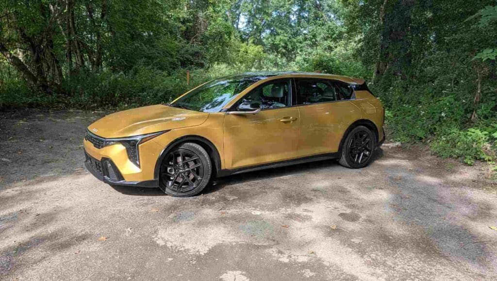 A side view of a gold 2026 Kia K4