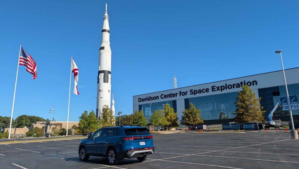 A rear shot of the 2027 Volkswagen Atlas with a Saturn V rocket in the background