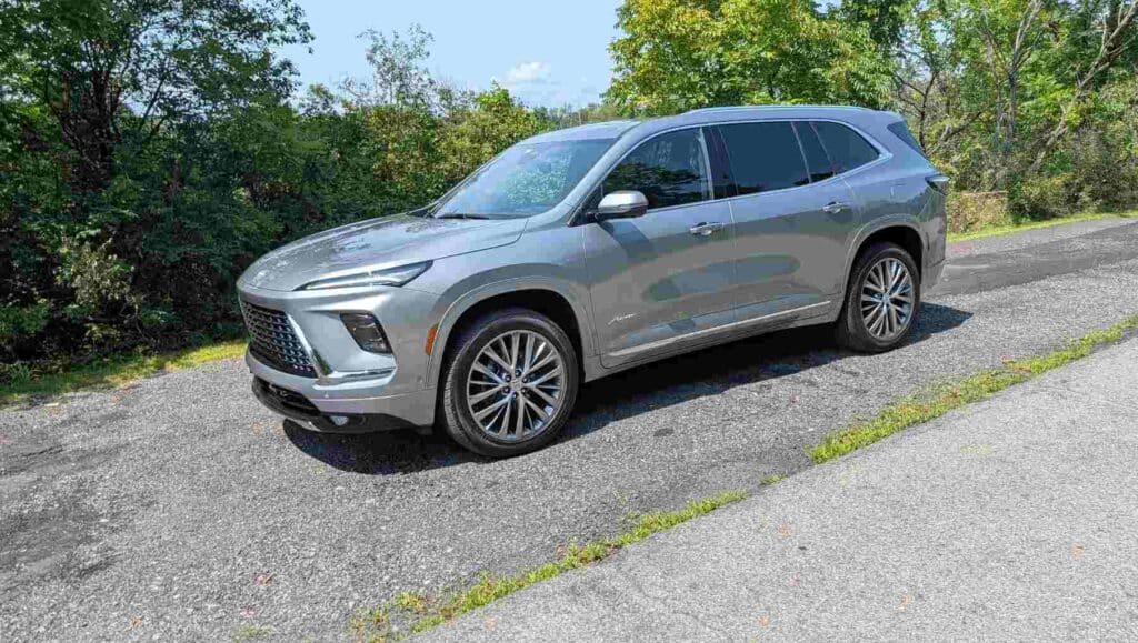Side view of a 2026 Buick Enclave Avenir in Silver descending a hill