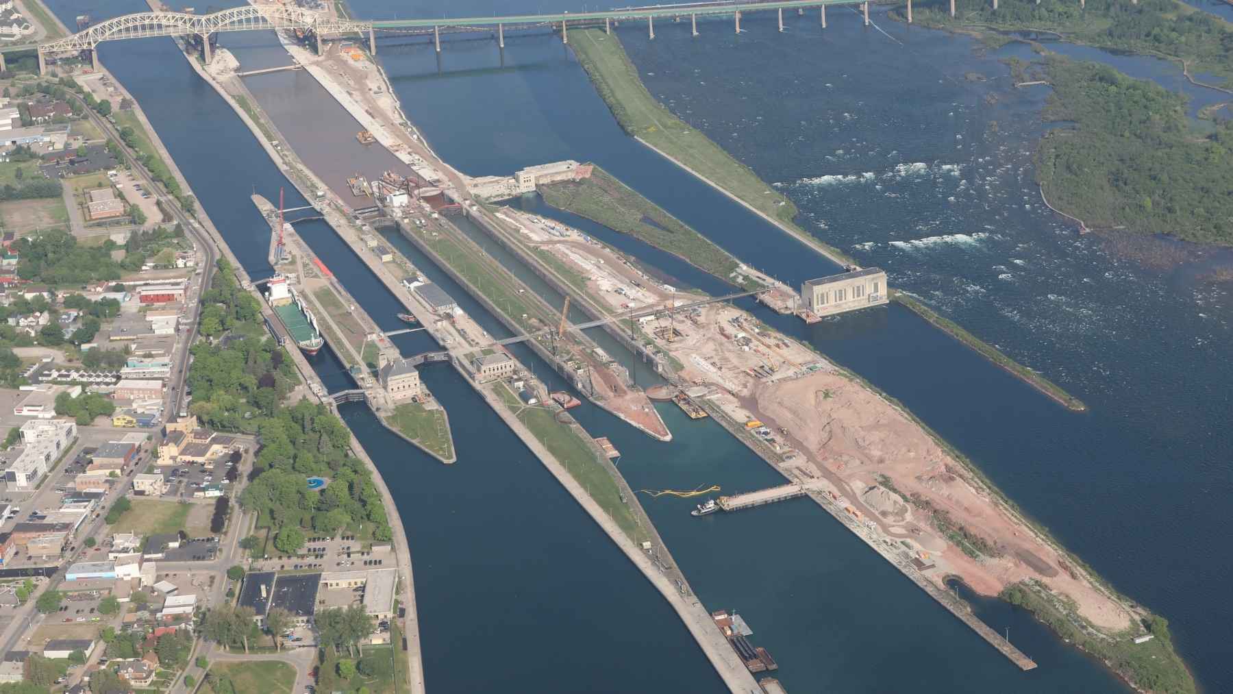 A 1,000-foot freighter going in or out of Lake Superior has exactly one lock it fits through, with 2.5 feet on each side, and the Army is halfway through the last phase of building it a 1,200-foot twin, because losing the first for weeks could idle 75% of US steel output