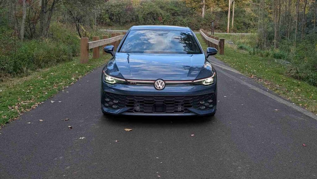 A front view of a A side view of a blue 2026 Volkswagen Golf GTI
