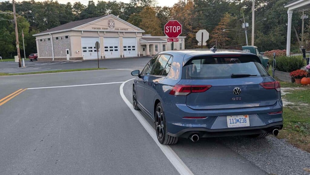 A rear view of a A side view of a blue 2026 Volkswagen Golf GTI