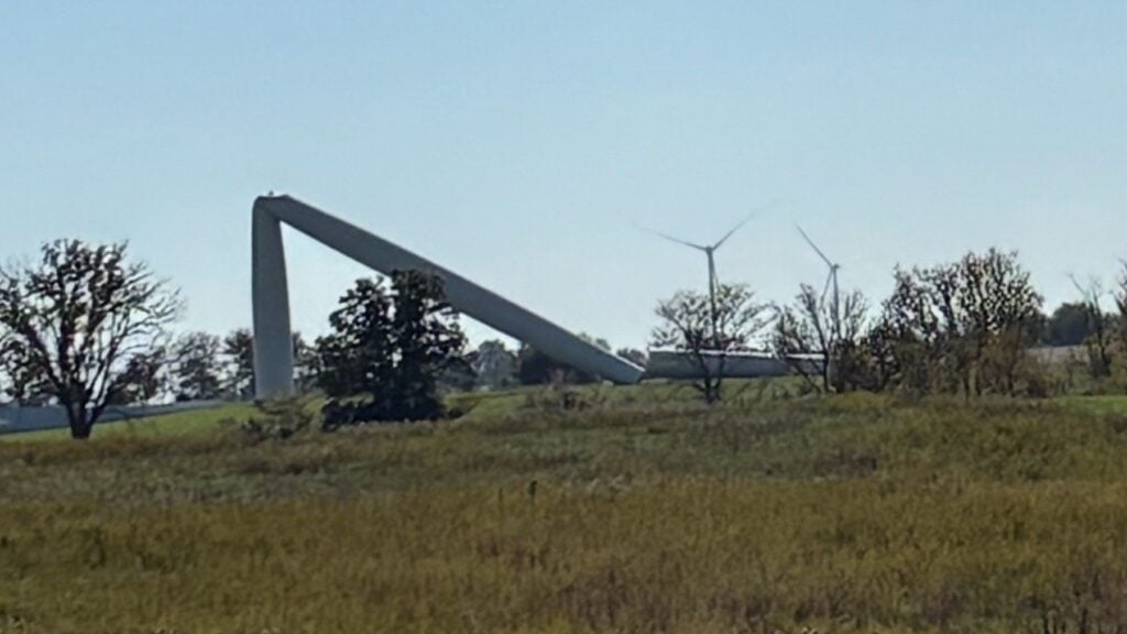 Bent wind turbine tower on the horizon seen across prairie grass in Adair County, Missouri